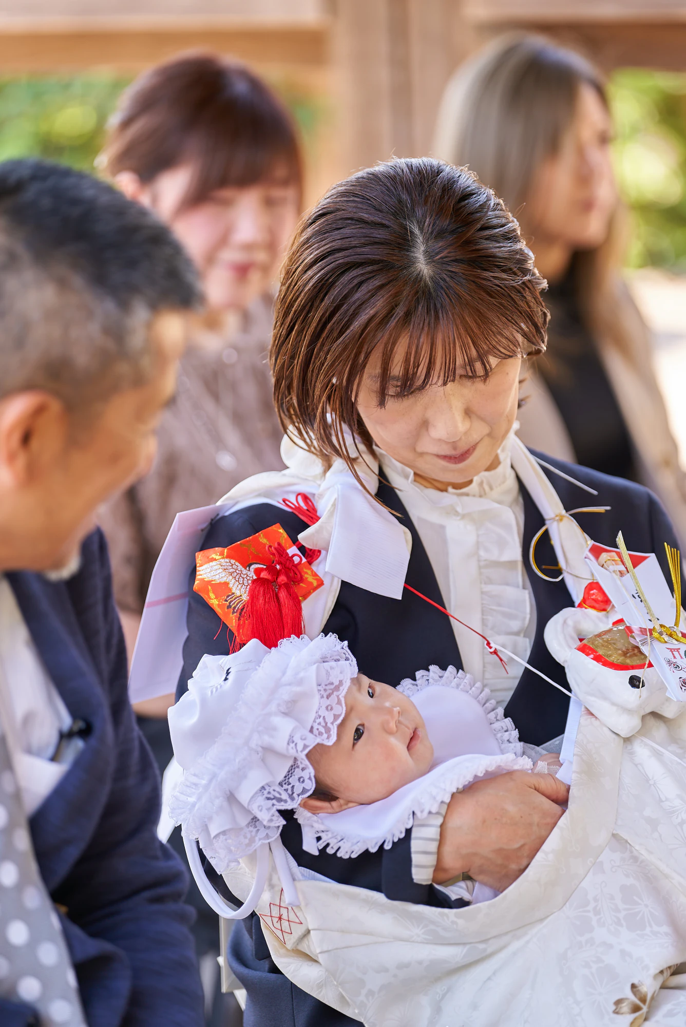 ご祈祷中に赤ちゃんを抱くおばあ様