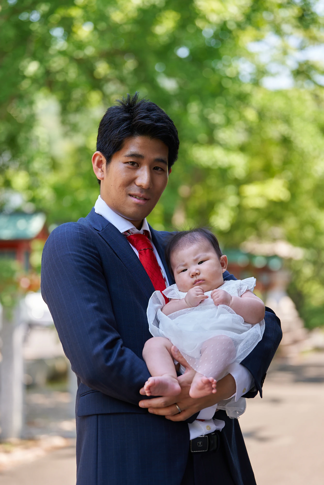 赤ちゃんを抱いて微笑むお父様