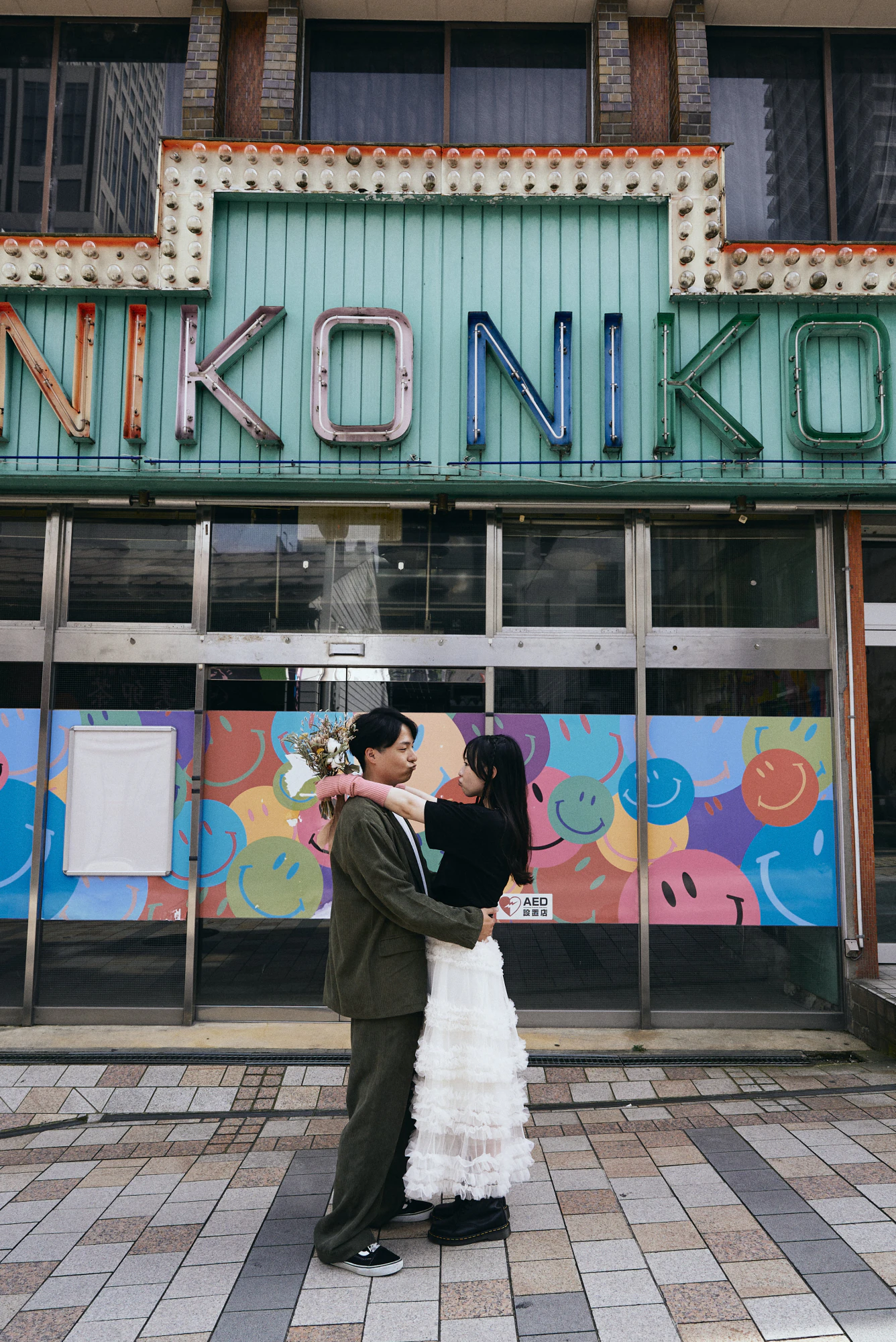 レトロな看板の前で抱き合うカップル ストリートフォトウェディング