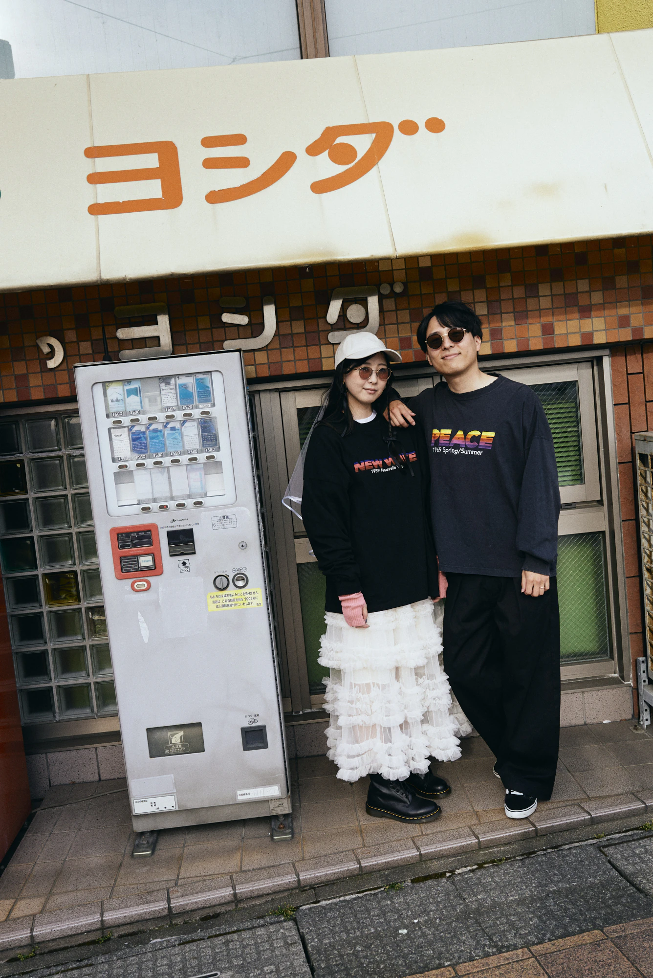 レトロな自動販売機の前に立つふたり