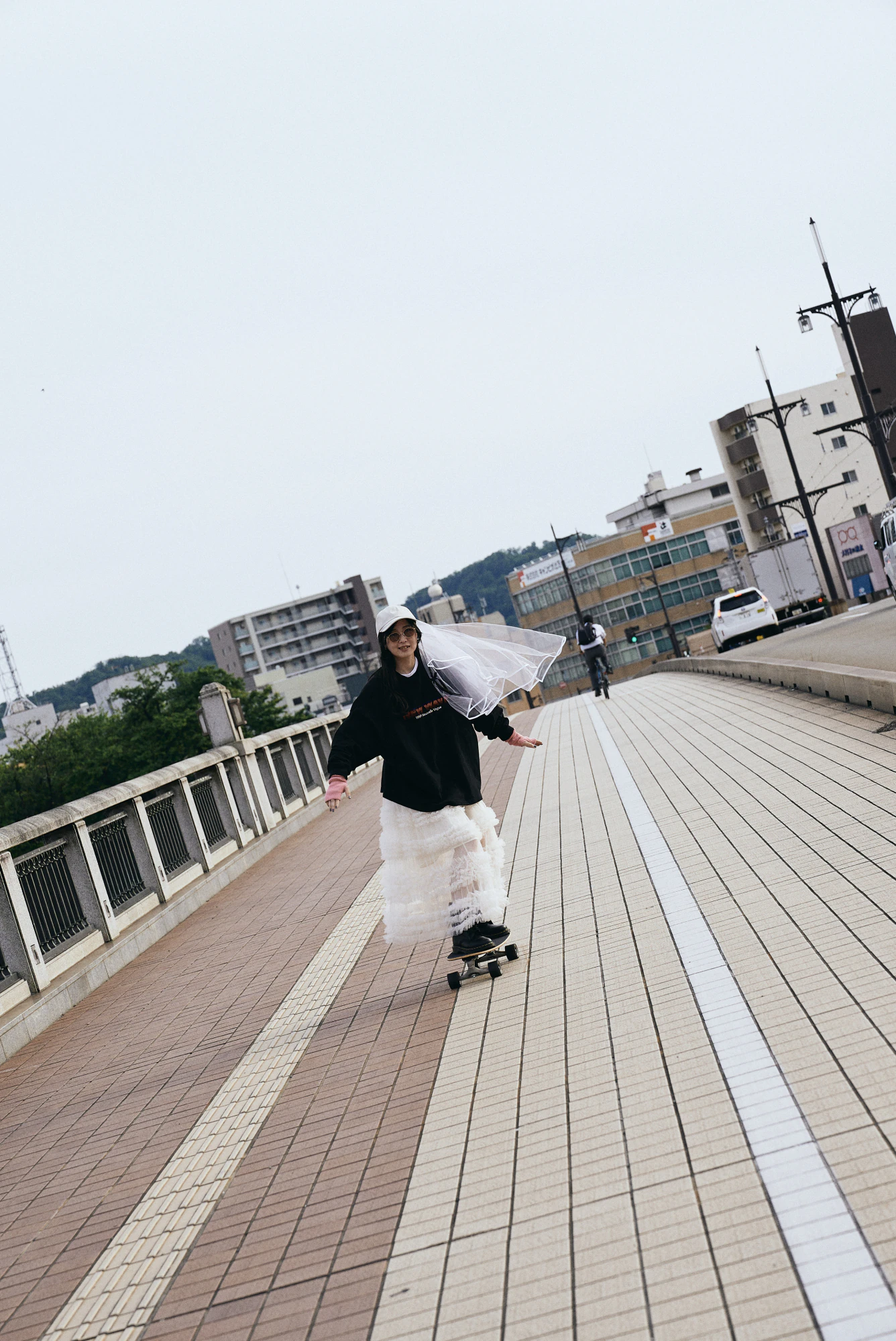橋の上をスケートボードで進む花嫁