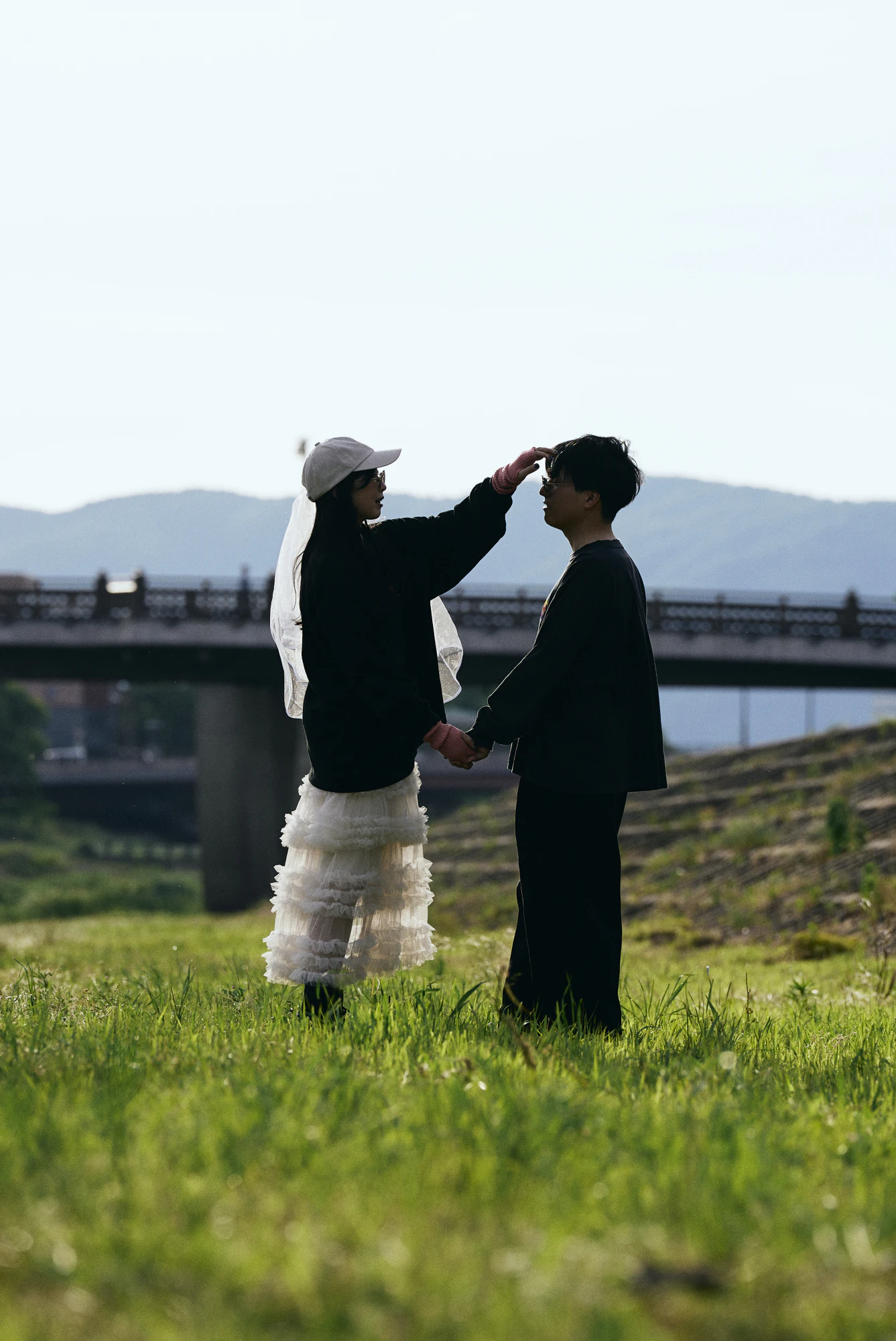夕方の河川敷でベールを直すふたり