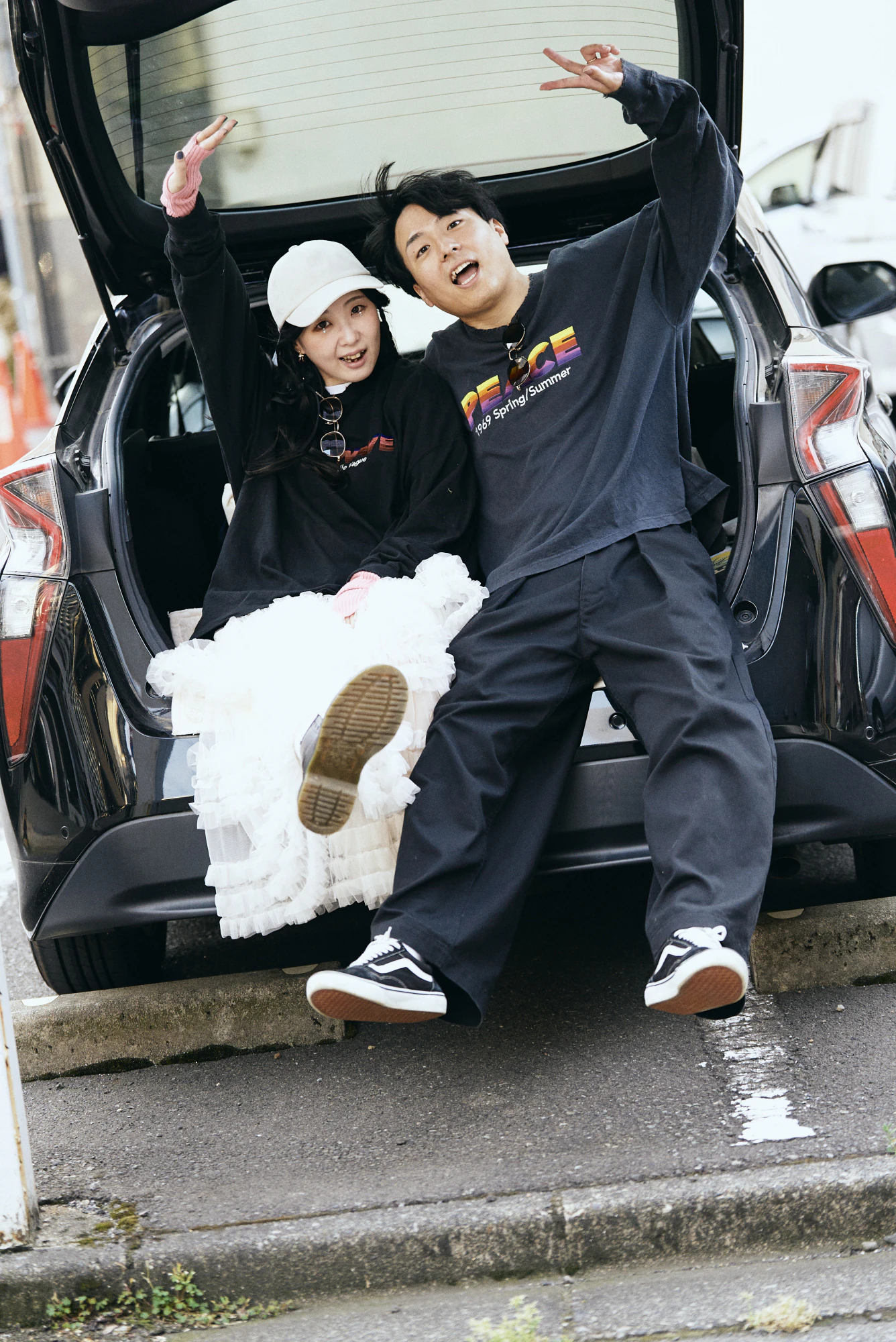 車のトランクに座ってはしゃぐふたり