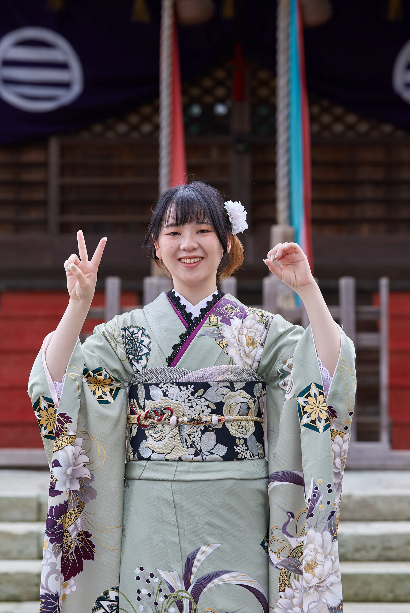 神社の前でピースする振袖姿