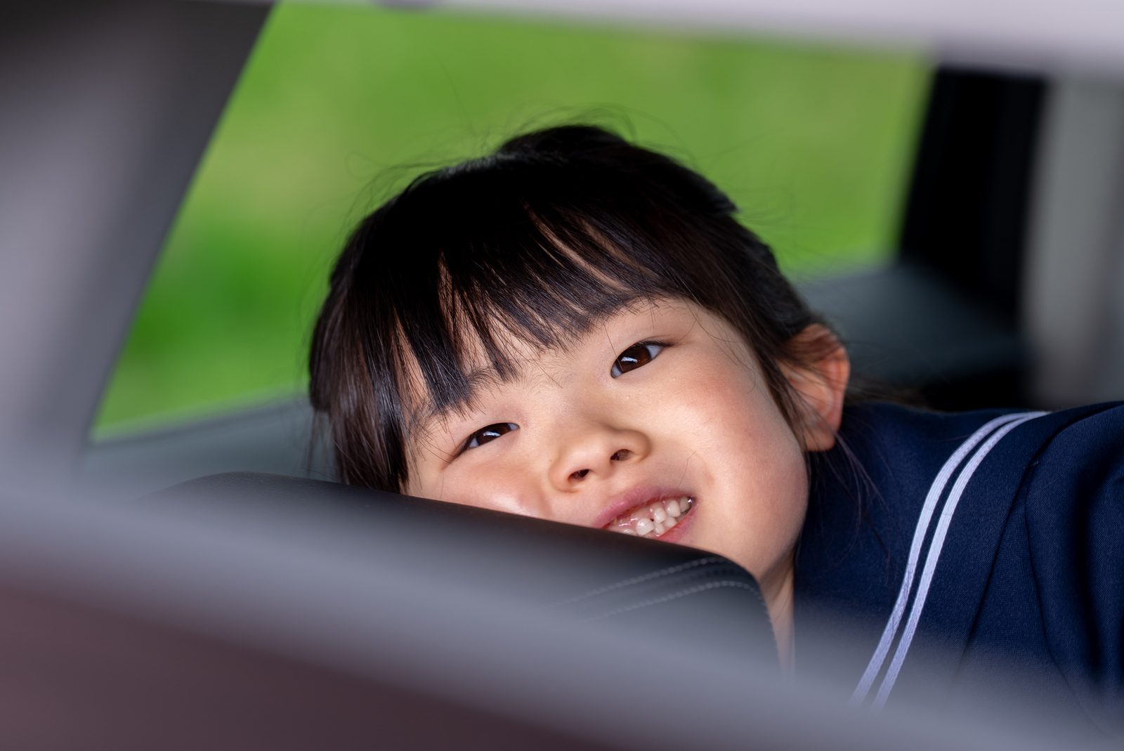 撮影の帰り、車の窓から顔を出して笑う女の子