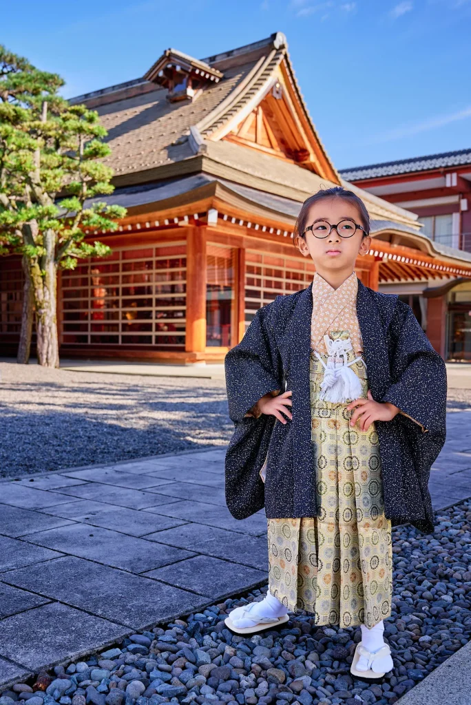 神明神社の社殿前に立つ羽織袴姿の5歳の男の子