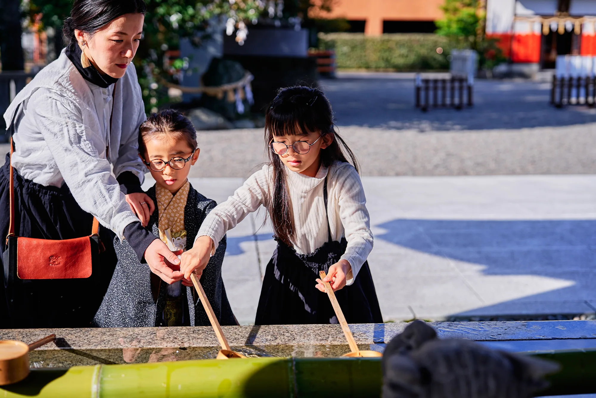 手水舎で手を清める七五三の姉弟