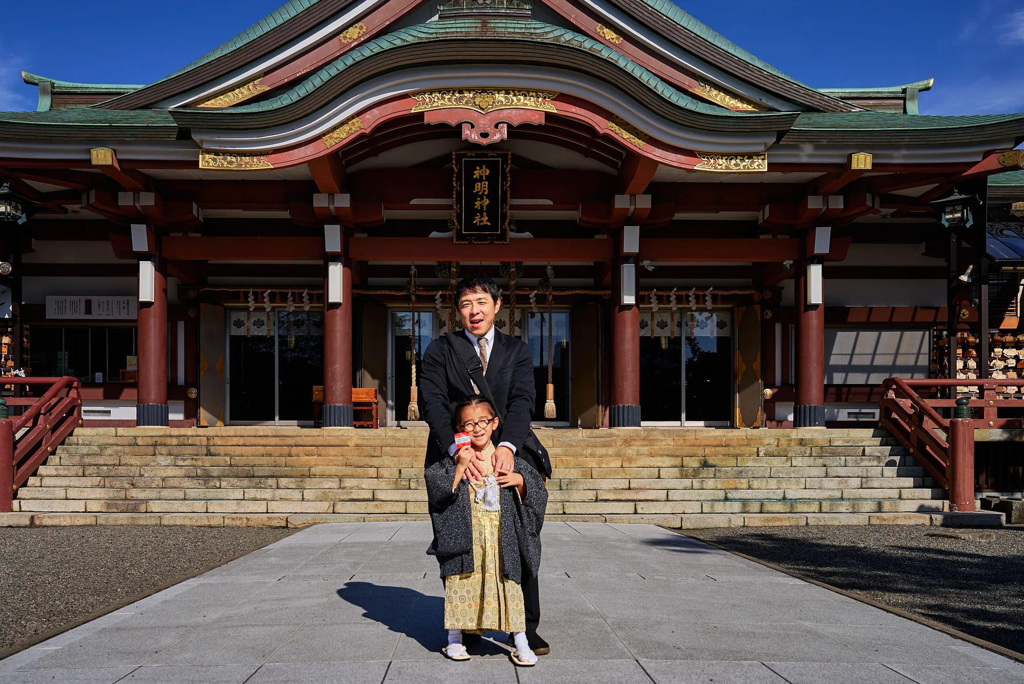 父親と社殿前に立つ七五三の男の子