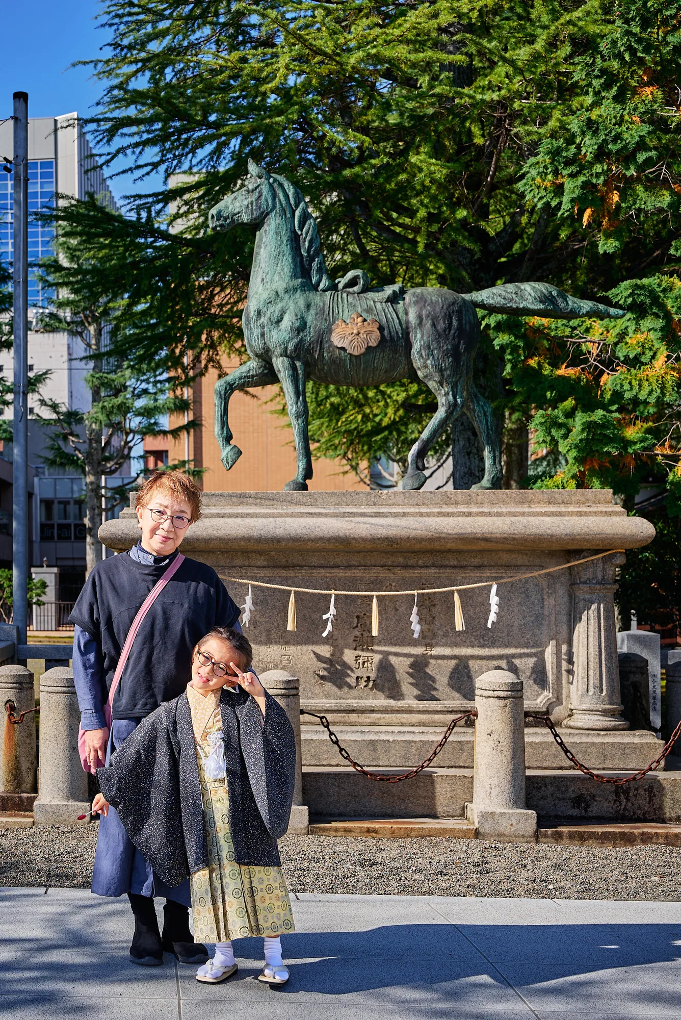 神明神社の神馬像の前に並ぶ姉弟