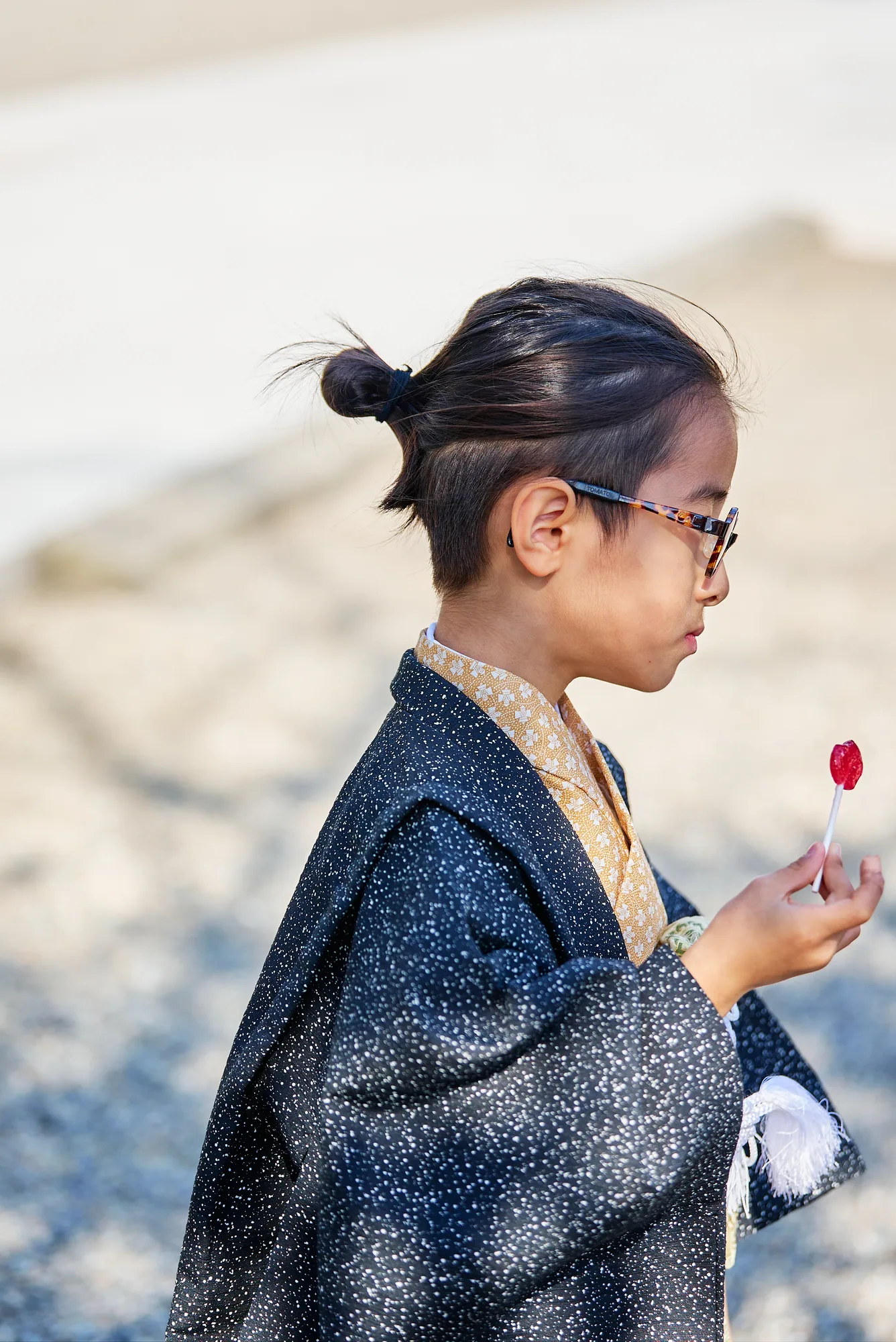 千歳飴をなめる七五三の男の子の横顔