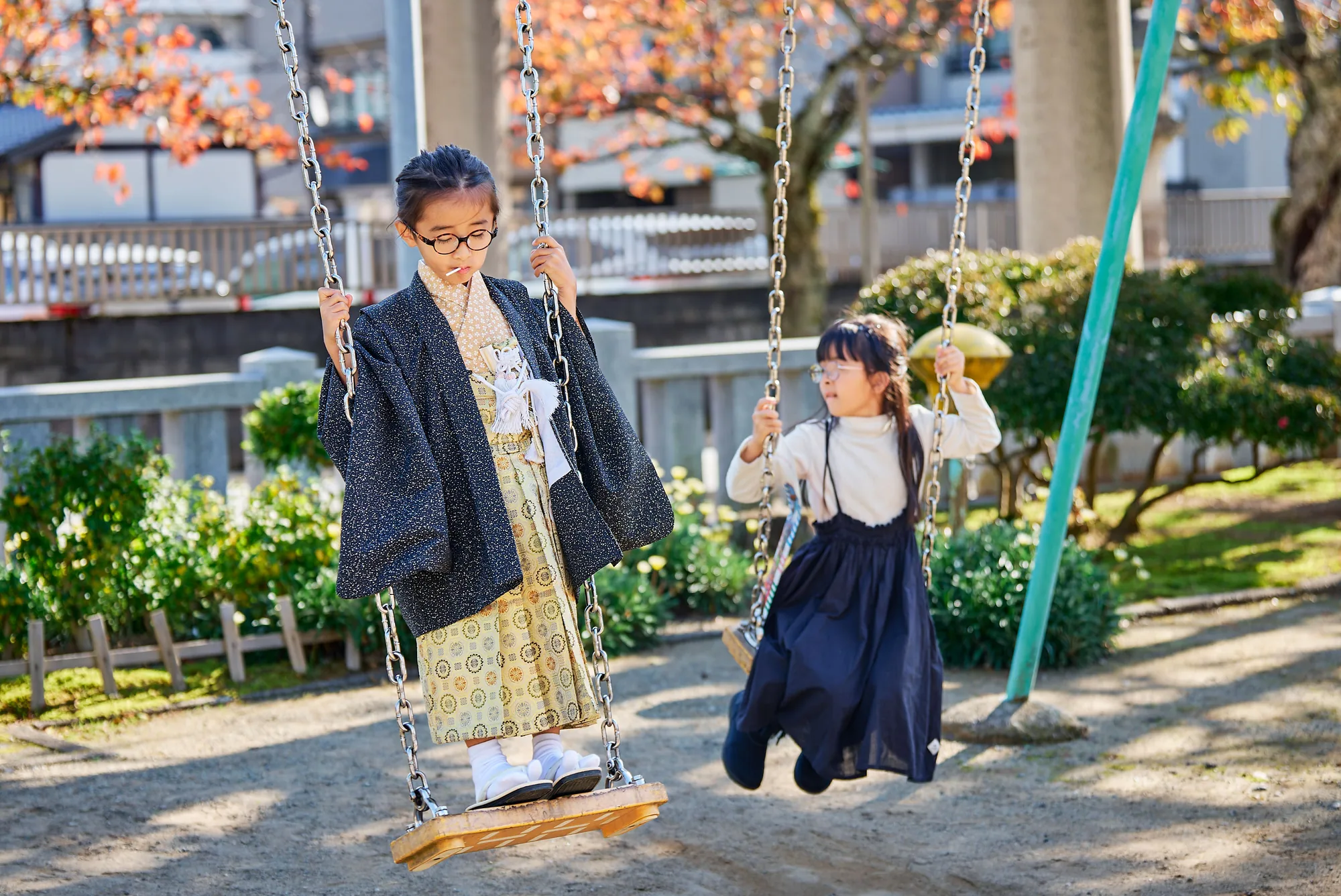 境内そばの公園でブランコに乗る姉弟