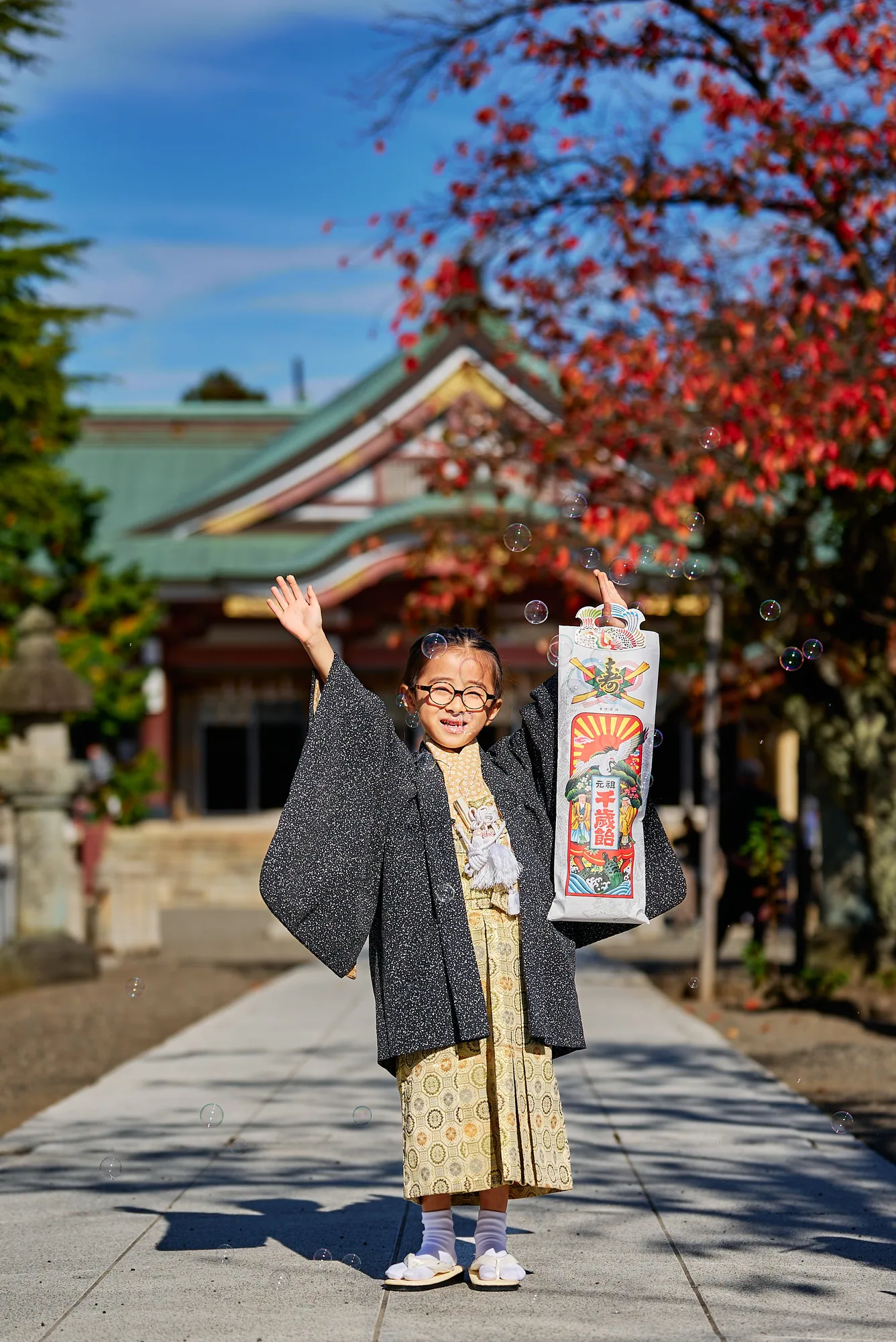 千歳飴を掲げて喜ぶ七五三の男の子