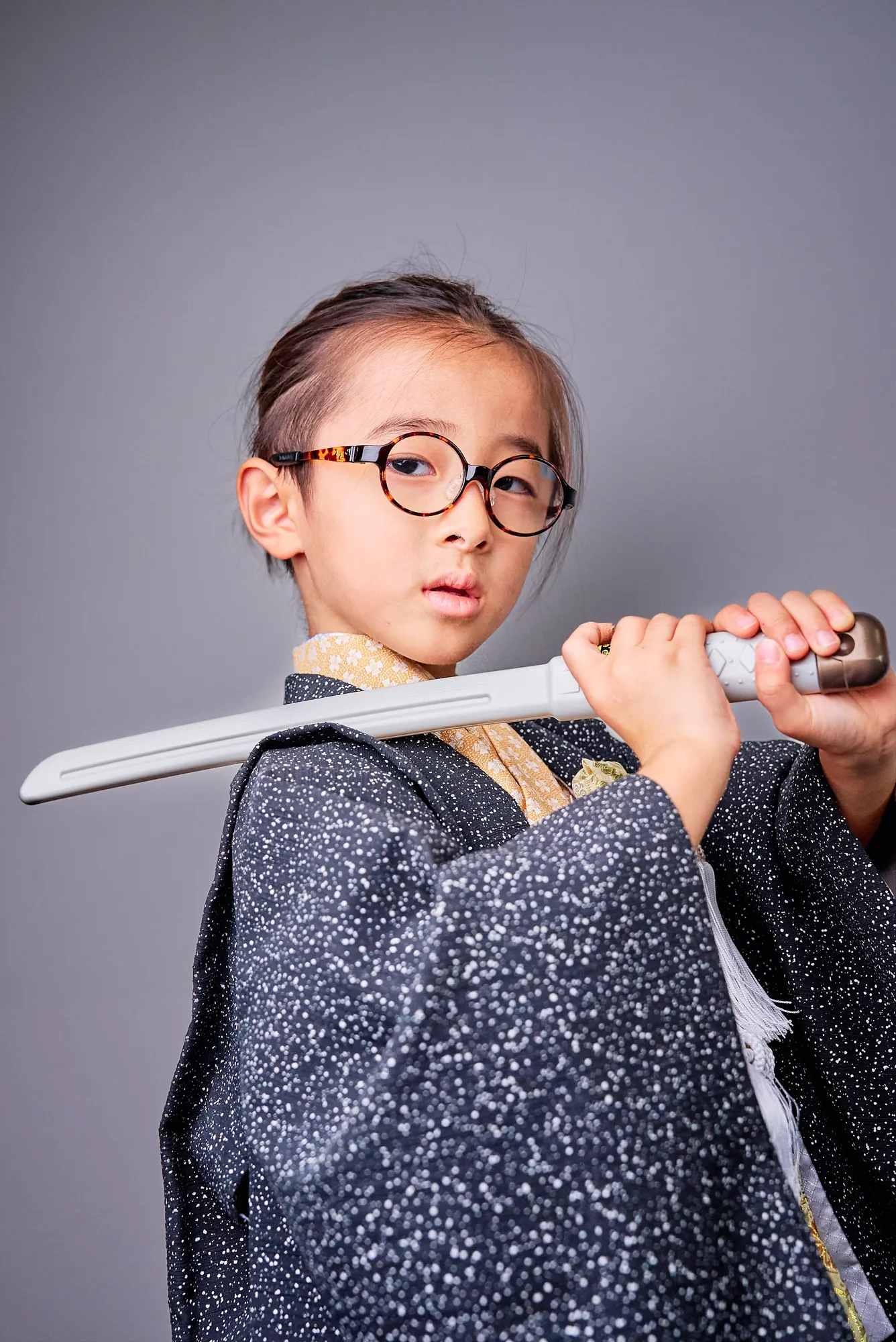 刀を構えるポーズをとる羽織姿の男の子