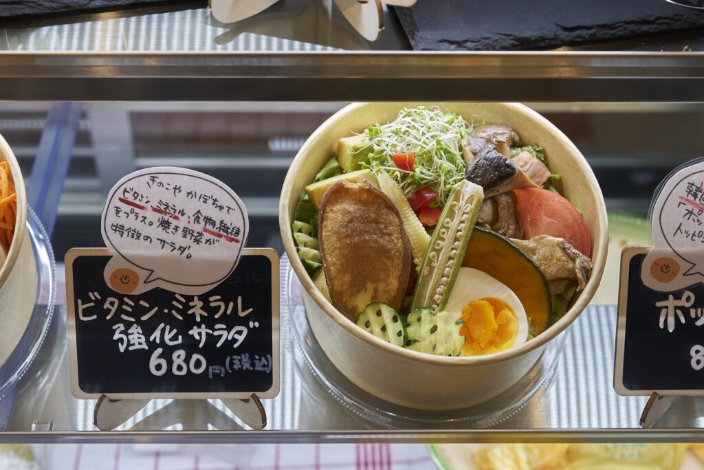 値札の添えられたサラダが並ぶ店内のショーケース
